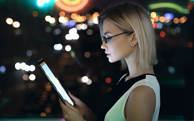 Woman holding a tablet at night