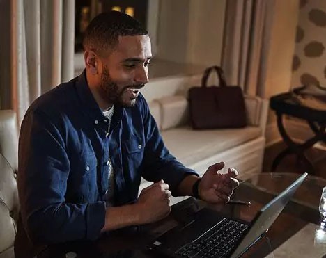 Man looking to laptop laughing